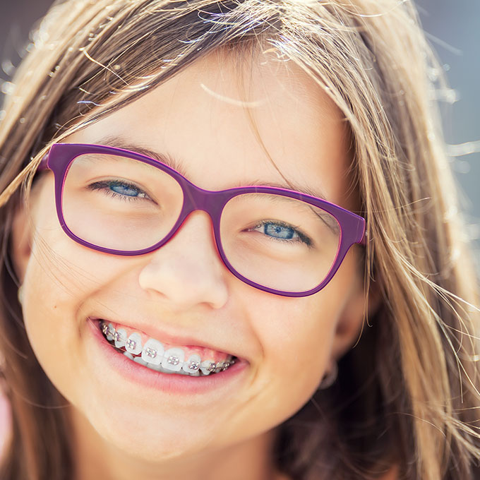 Smiling girl with braces on teeth
